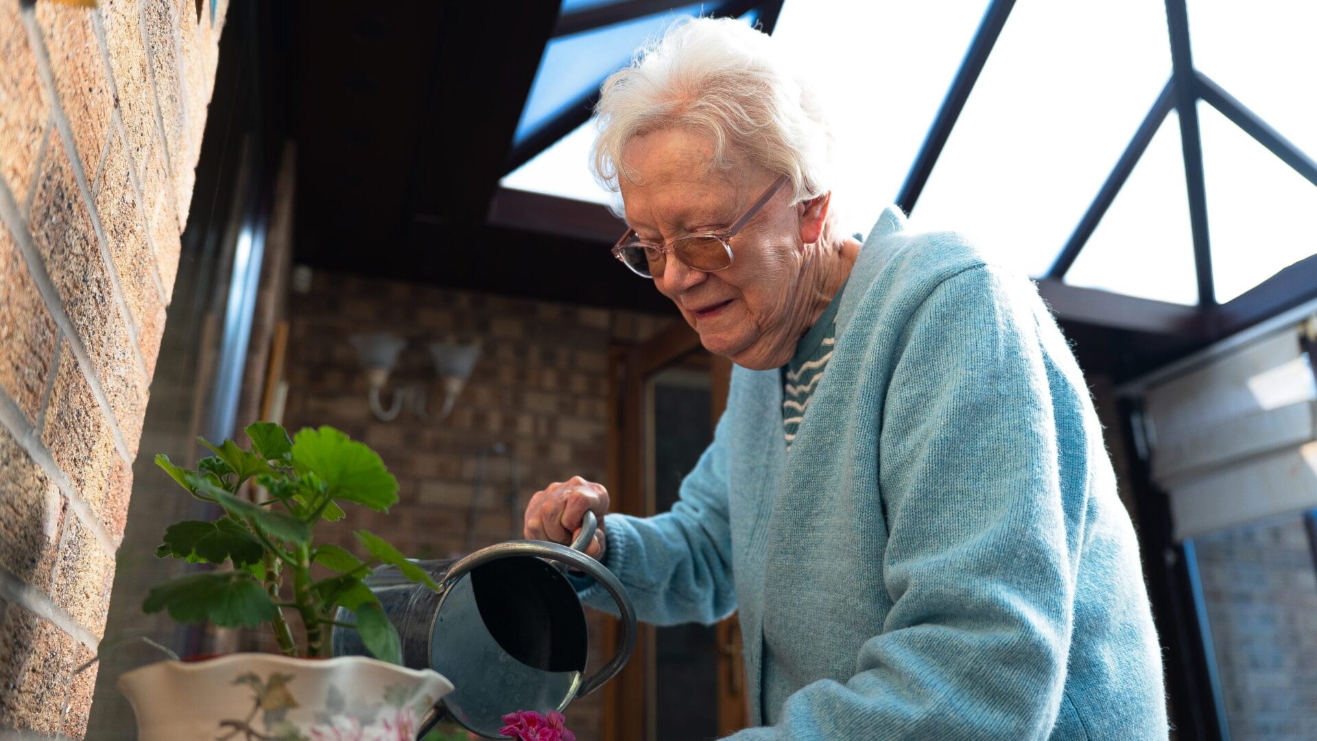Older white woman watering flowers