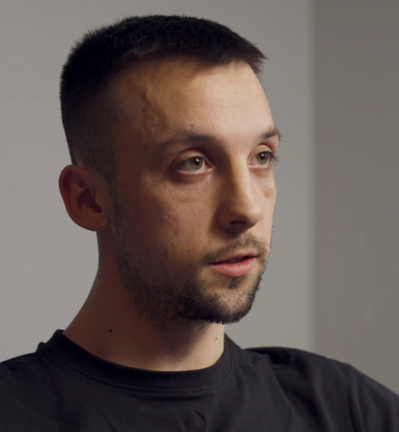 A young man with dark hair speaking