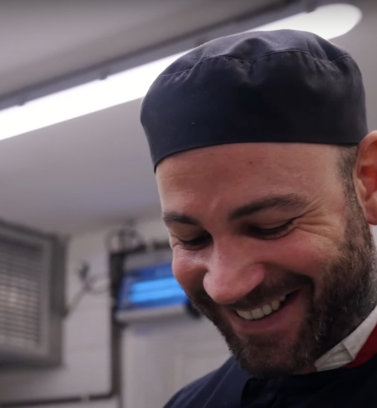 Smiling man with beard in chef's uniform