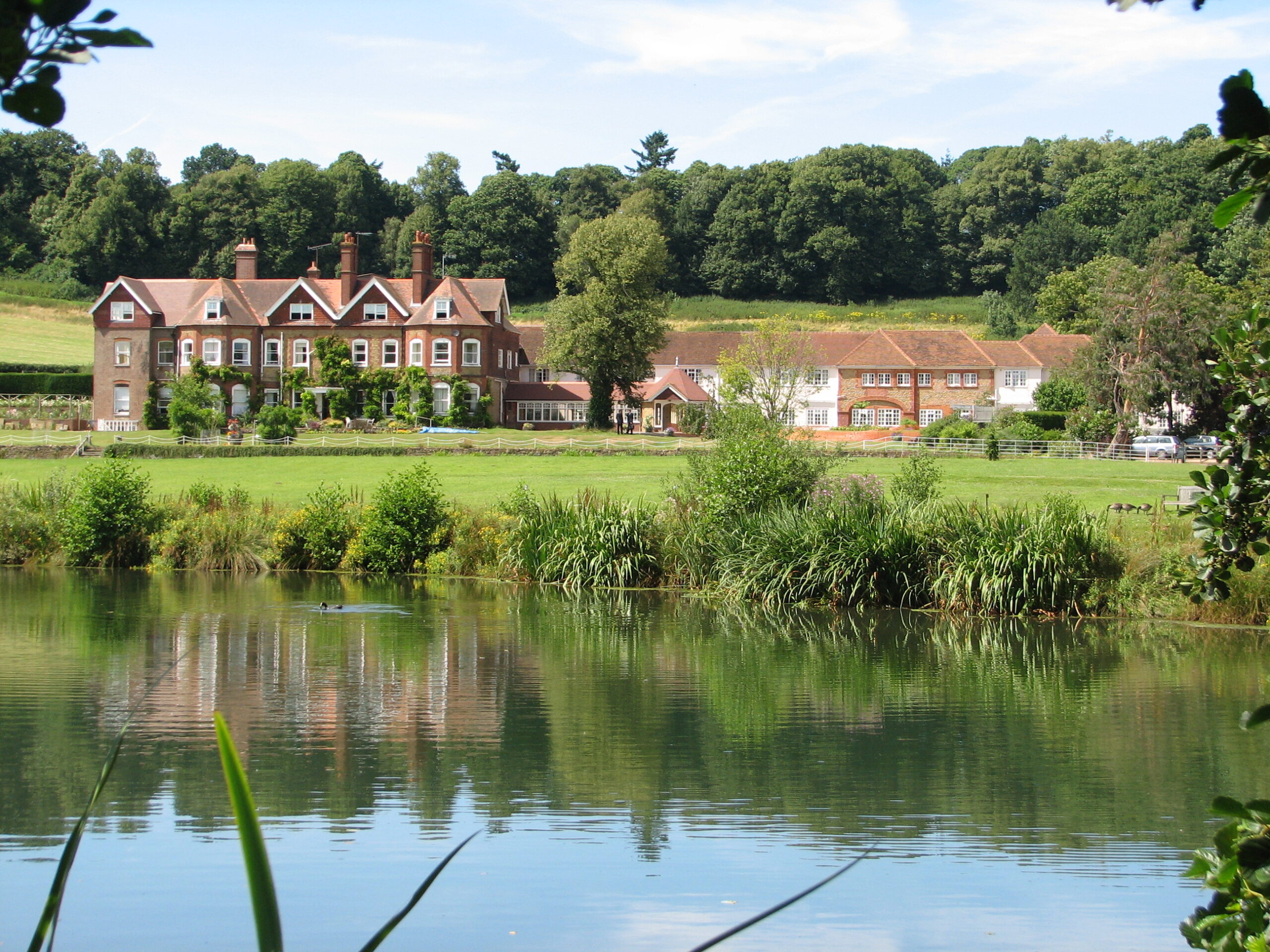 The Birtley House Historic Building stood against the countryside backdrop in the back ground and fishing lake in the front of the house.
